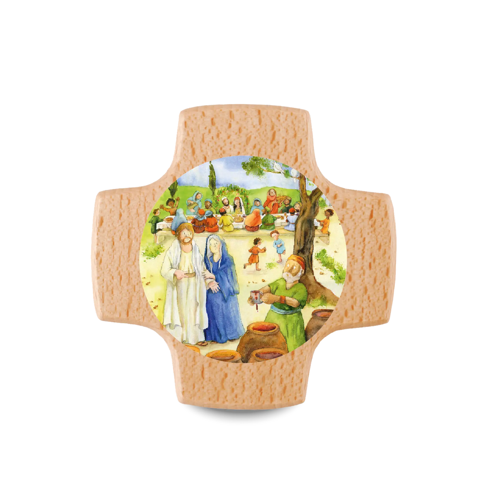 Das liebevoll gestaltete Motiv auf einem Holzkreuz zeigt eine fröhliche Szene rund um Jesus und vermittelt Wärme, Gemeinschaft und Freude – passend zum großen Tag der Erstkommunion. Im Dorf Galiläa wird Hochzeit gefeiert. Kinder lachen, Erwachsene stoßen an, bis der Wein knapp wird. Maria vertraut Jesus.