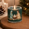 Grünes Windlicht mit brennender Flamme mit Motiv der heiligen Familie auf einem braunen Tisch mit Weihnachtsbaum Hintergrund