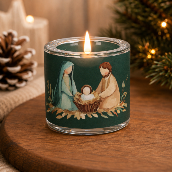 Grünes Windlicht mit brennender Flamme mit Motiv der heiligen Familie auf einem braunen Tisch mit Weihnachtsbaum Hintergrund