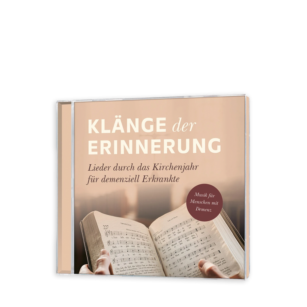 Eine CD mit Cover Klänge der Erinnerung in weiß und der Unterüberschrift Lieder durch das Kirchenjahr für demenziell Erkrankte mit einem Gesangsbuch in Händen