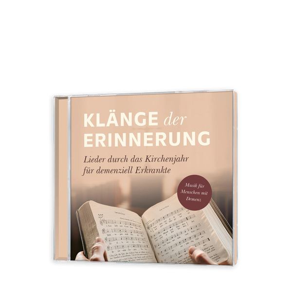 Eine CD mit Cover Klänge der Erinnerung in weiß und der Unterüberschrift Lieder durch das Kirchenjahr für demenziell Erkrankte mit einem Gesangsbuch in Händen