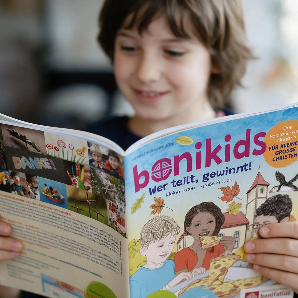 Junge hält Bonikids-Zeitschrift. Das Titelblatt zeigt 3 Kinder die einen Pizzakarton halten und sich die Pizza teilen, im Hintergrund ist eine Kirche, Papageientaucher fliegt über den Kindern. Thema der Ausgabe "Wer teilt, gewinnt!". Die Rückseite zeigt eine Collage DAnke.