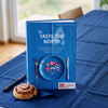 Kochbuch „Taste the North“ mit nordischen Spezialitäten auf blauem Esstisch