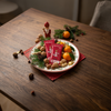 Rotes Gummibärchen auf Teller mit Nüssen und Weihnachtsschmuck